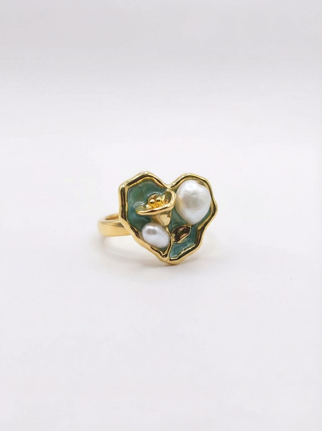 Gold ring with green enamel and pearl on a white background