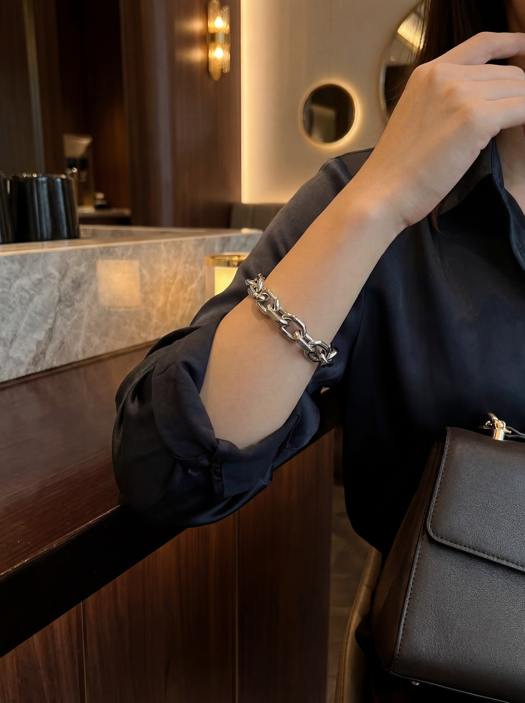 Person wearing a silver bracelet in an indoor setting
