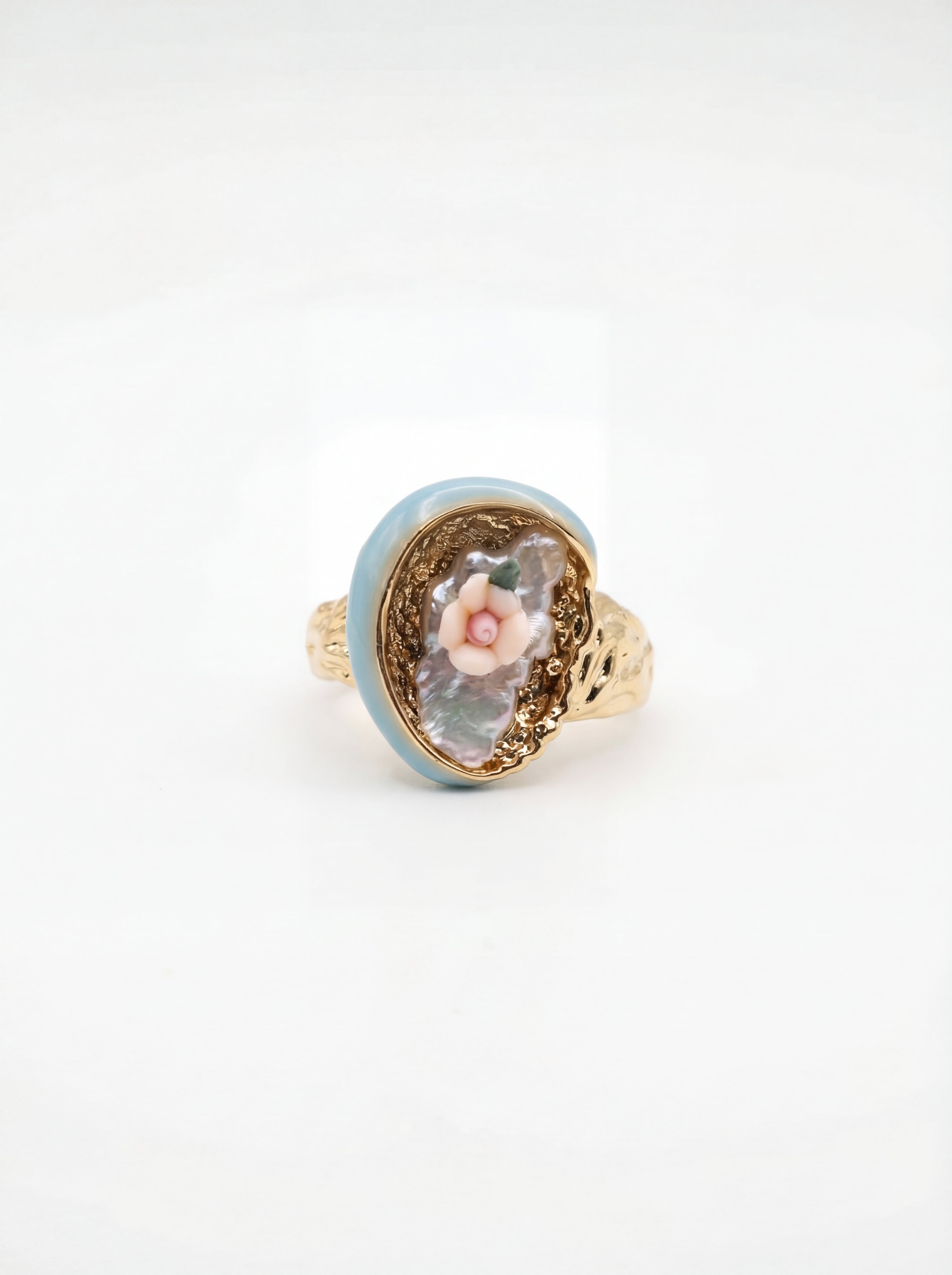 Ring with floral design and gold accents on a white background