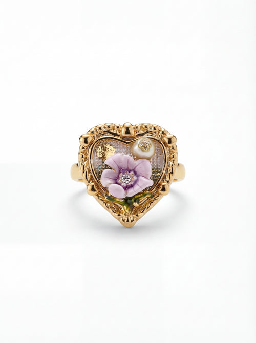 Heart-shaped gold ring with floral design on a white background