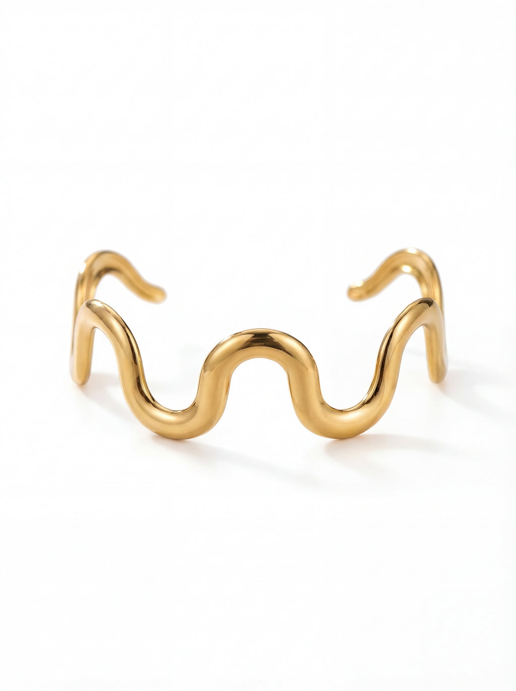 Gold wave-shaped cuff bracelet on a white background
