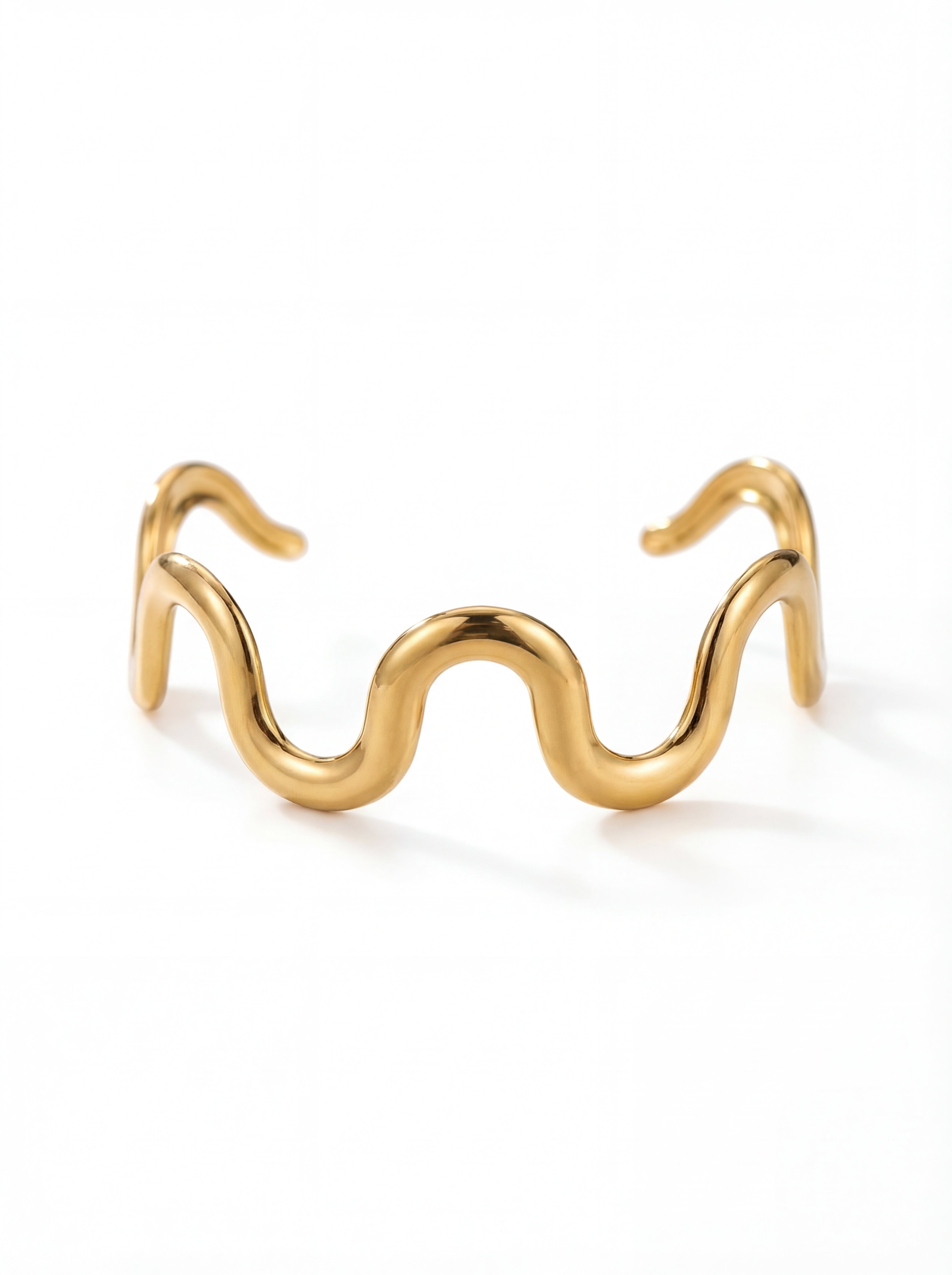 Gold wave-shaped cuff bracelet on a white background