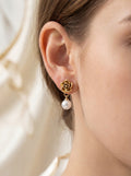 Person wearing gold flower-shaped earrings
