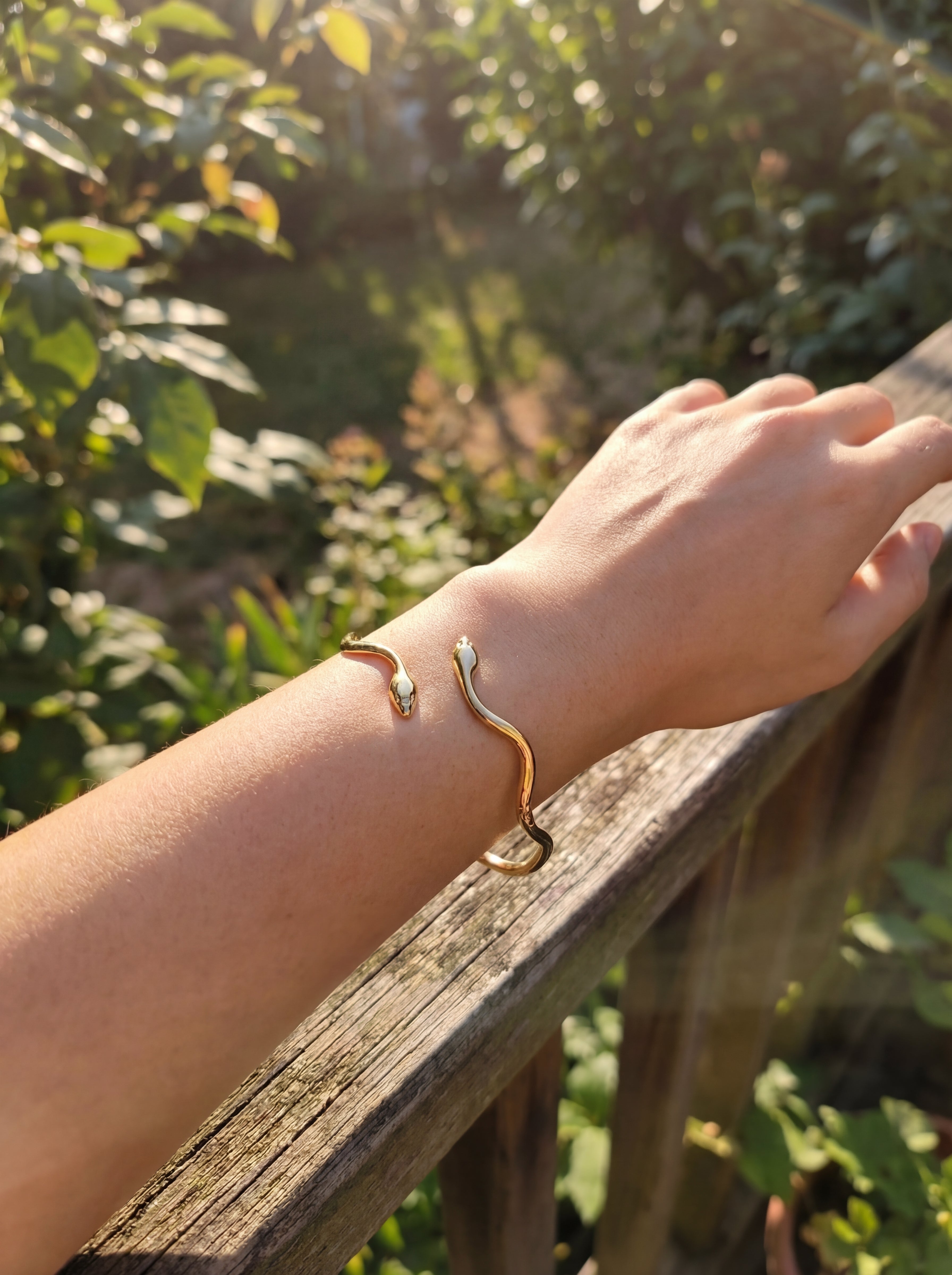 Person wearing a gold snake bangle