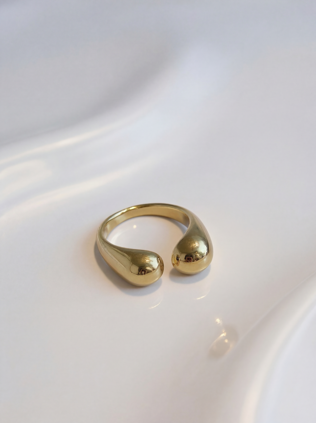 Gold ring with a unique design on a white surface