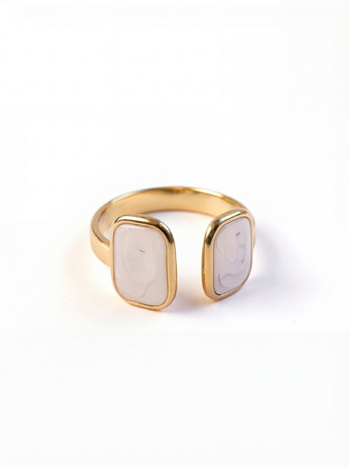 Gold ring with a white stone on a white background