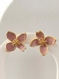 Pink flower-shaped earrings with gold accents on a white background