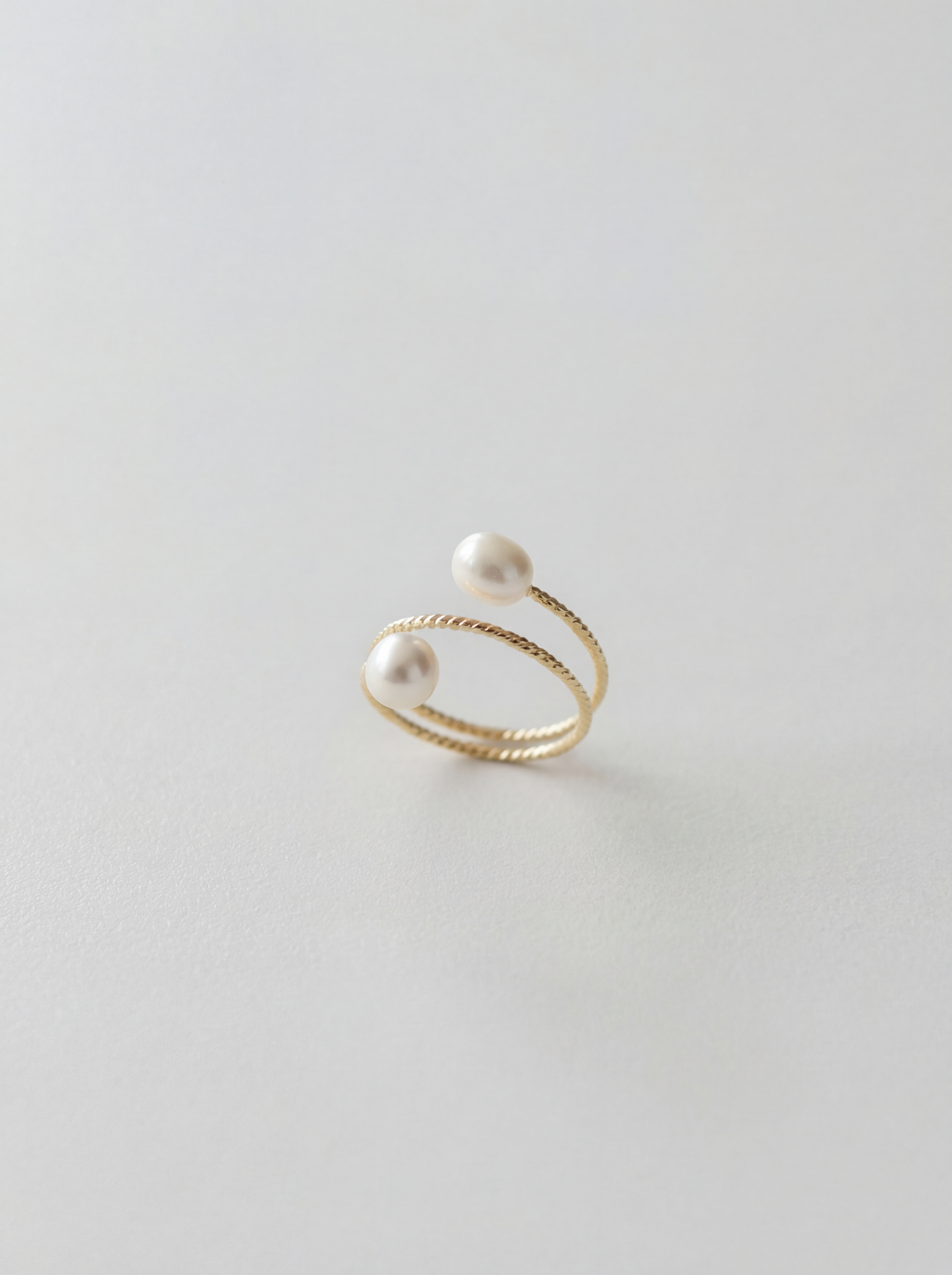 Gold ring with pearls on a light gray background
