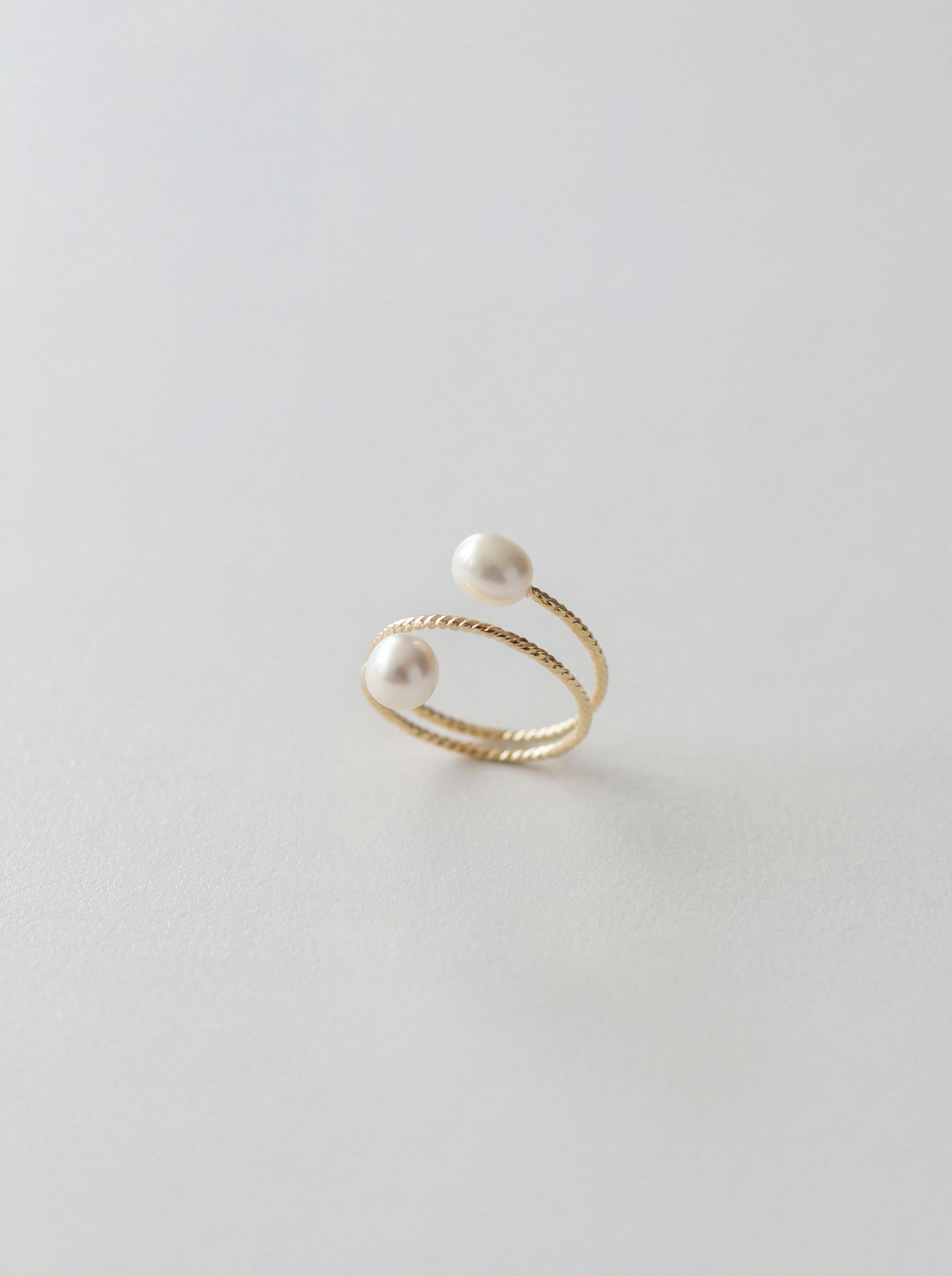 Gold ring with pearls on a light gray background