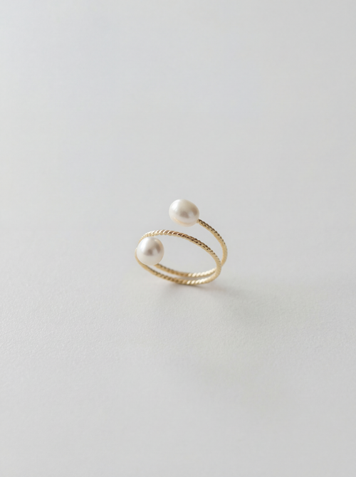 Gold ring with pearls on a light gray background
