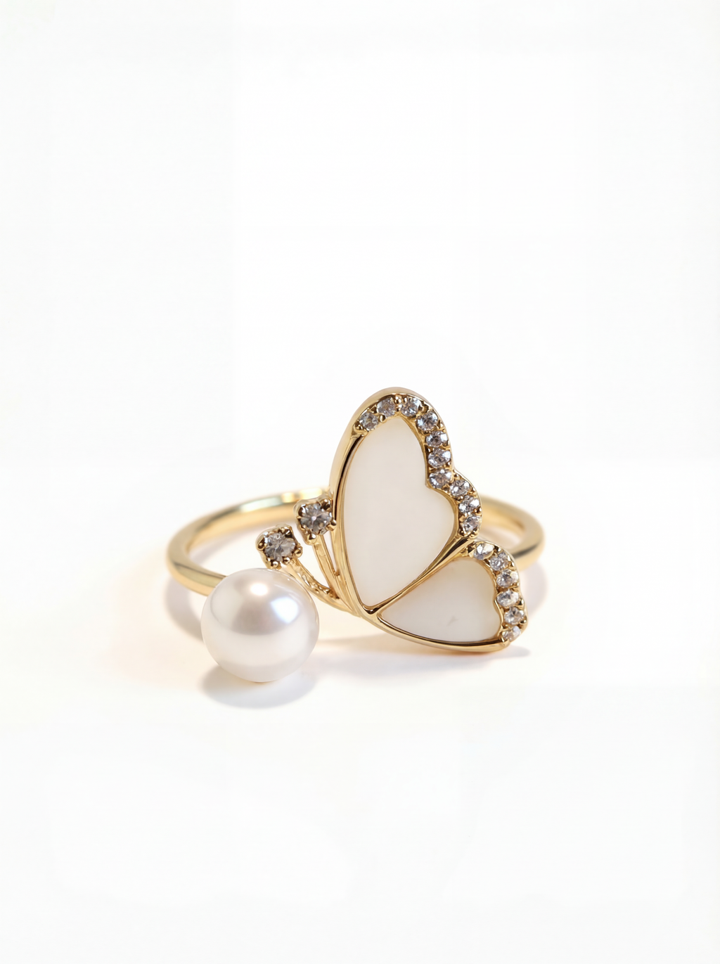Heart-shaped ring with pearl and gold accents on a white background
