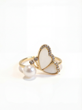 Heart-shaped ring with pearl and gold accents on a white background