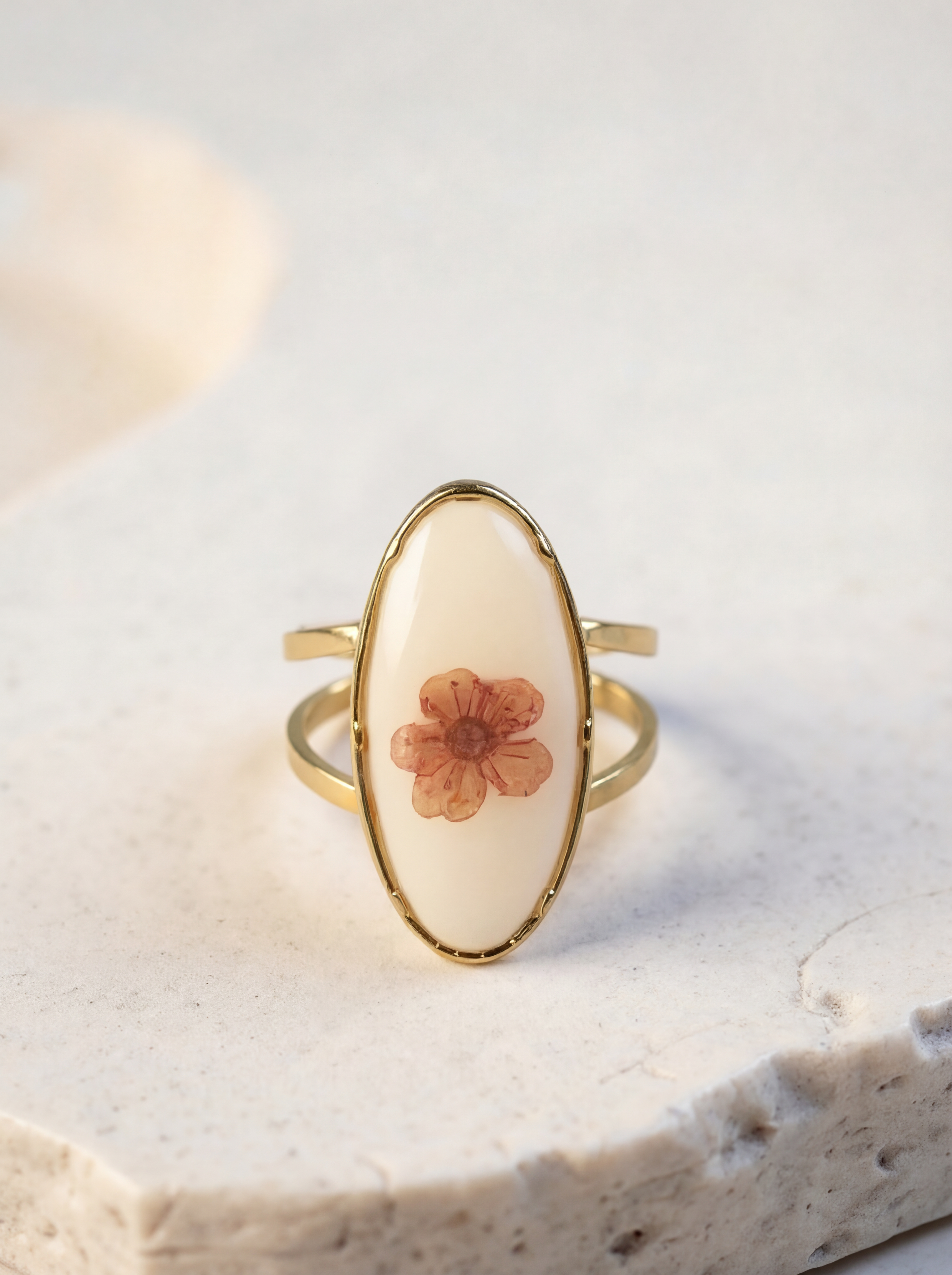 Ring with a floral design on a light stone surface