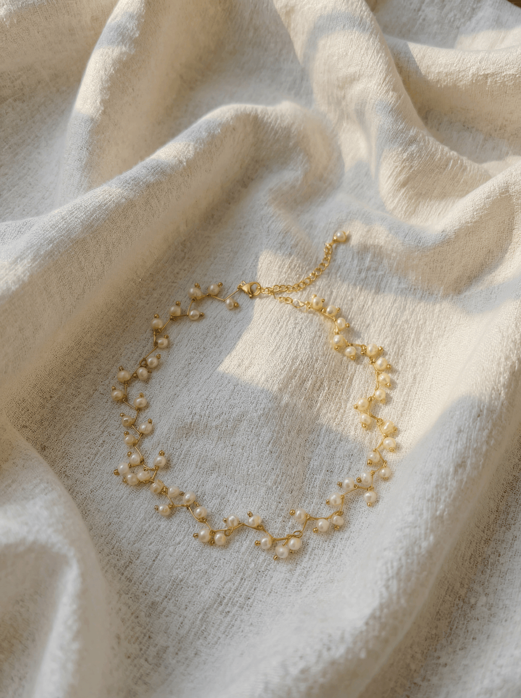 Pearl necklace on a textured beige fabric background