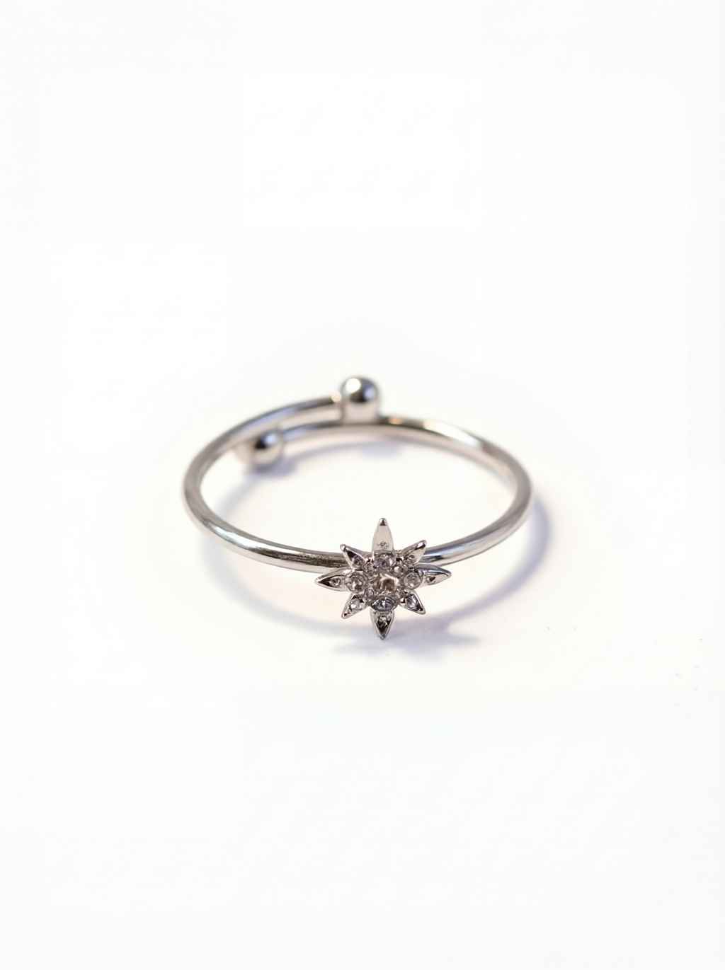 Silver ring with a star-shaped diamond on a white background