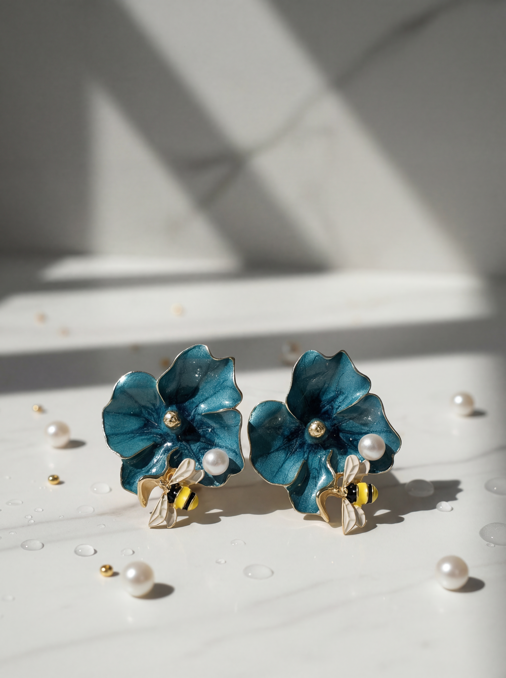 Blue flower earrings with pearl accents on a light surface.