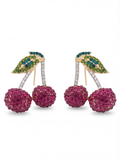 Cherry-themed earrings with pink gemstones and green leaves on a white background