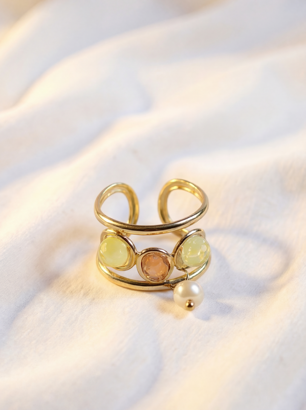 Gold ring with gemstones on a white fabric background