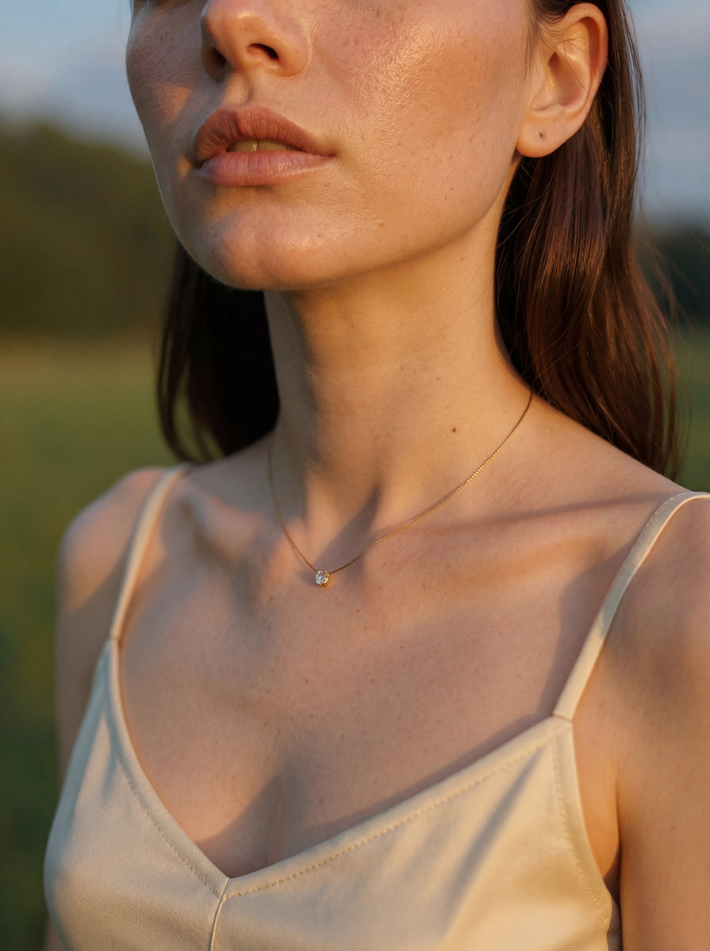 Woman wearing a beige tank top with a blurred background