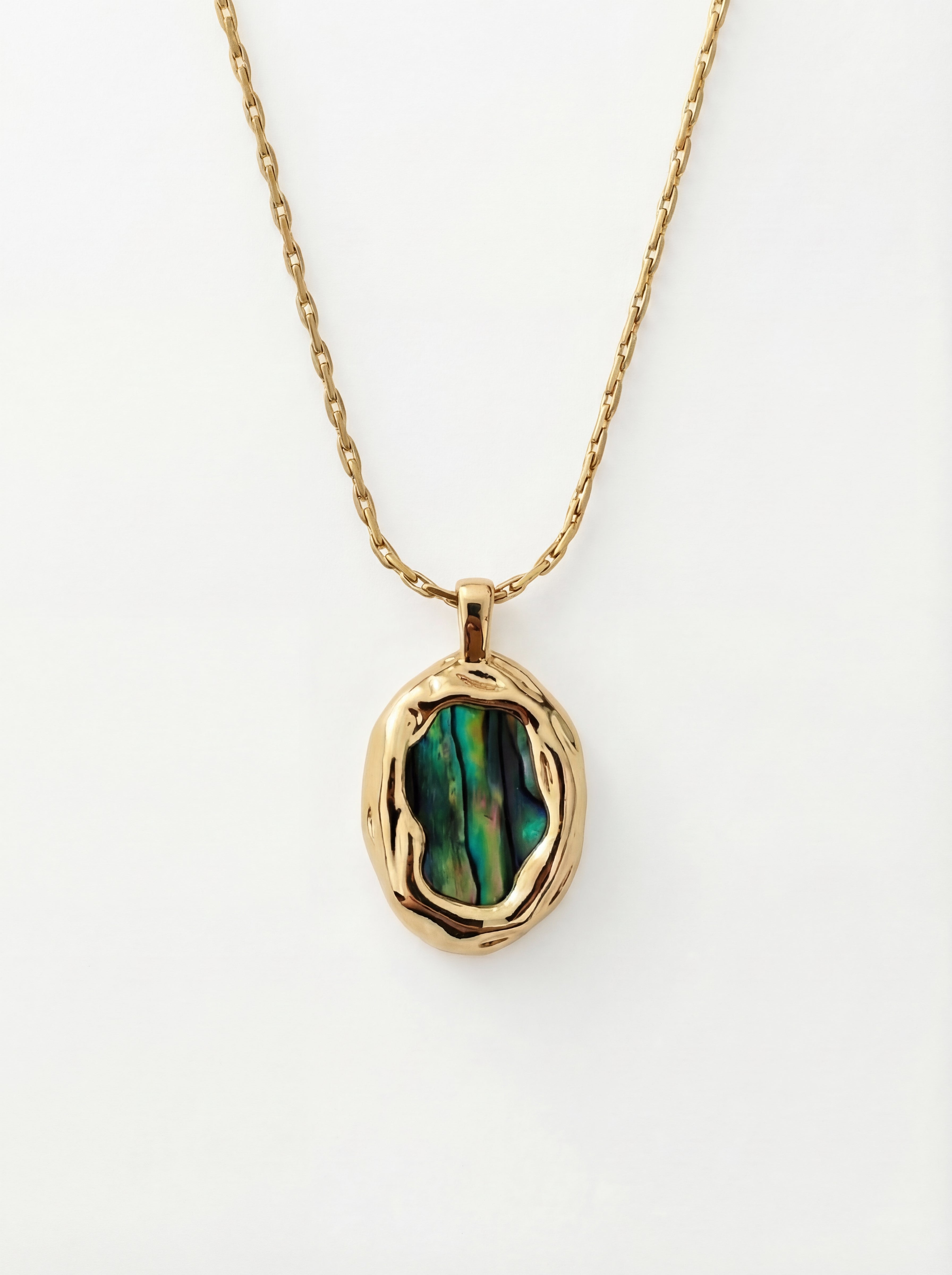 Gold necklace with a green stone pendant on a white background