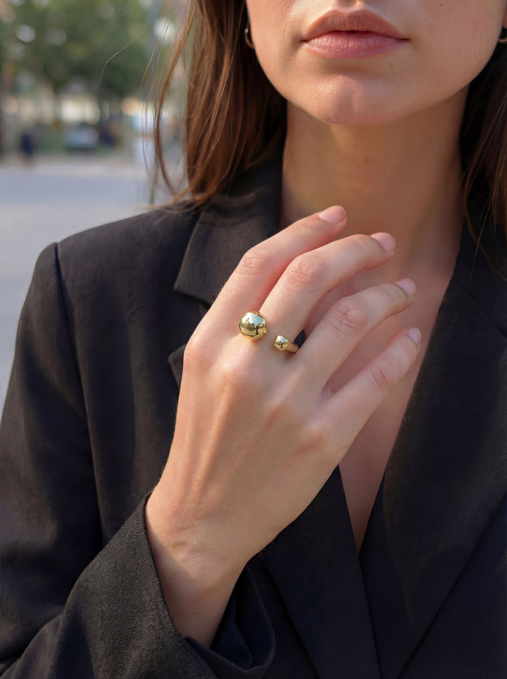 Close-up of a person wearing a gold ring outdoors