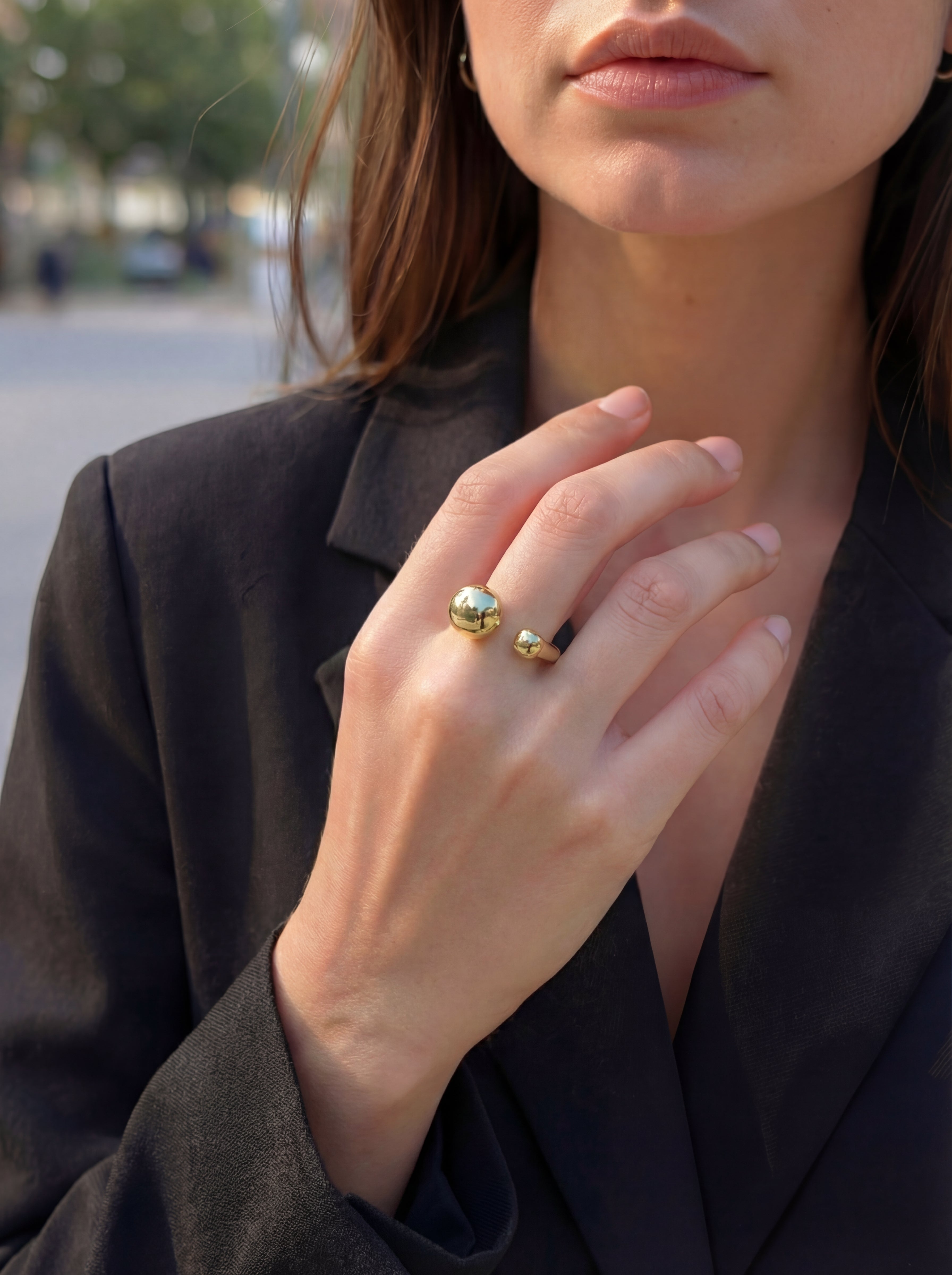 Close-up of a person wearing a gold ring outdoors