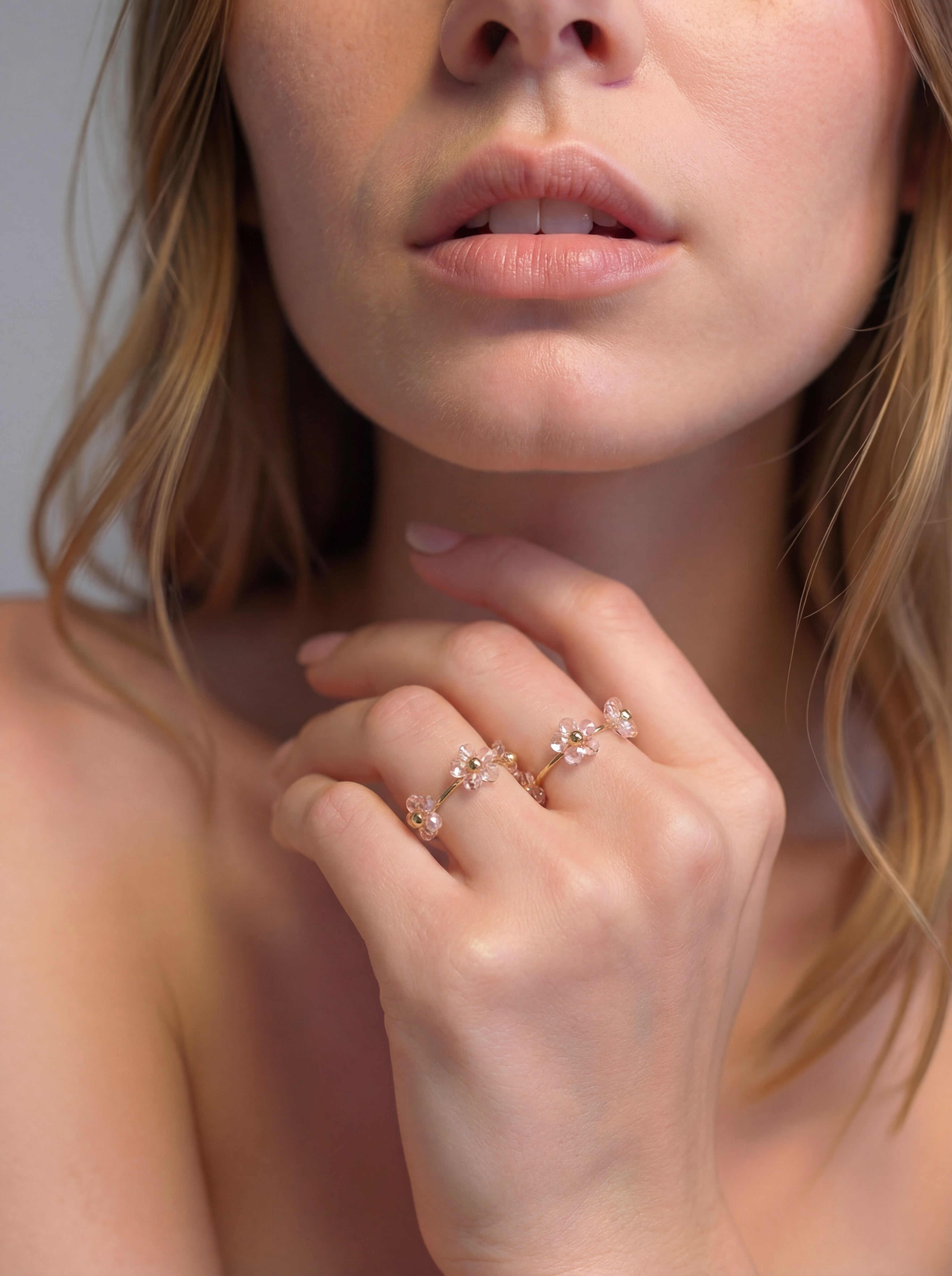 Close-up of a woman's hand wearing a delicate ring with floral design.