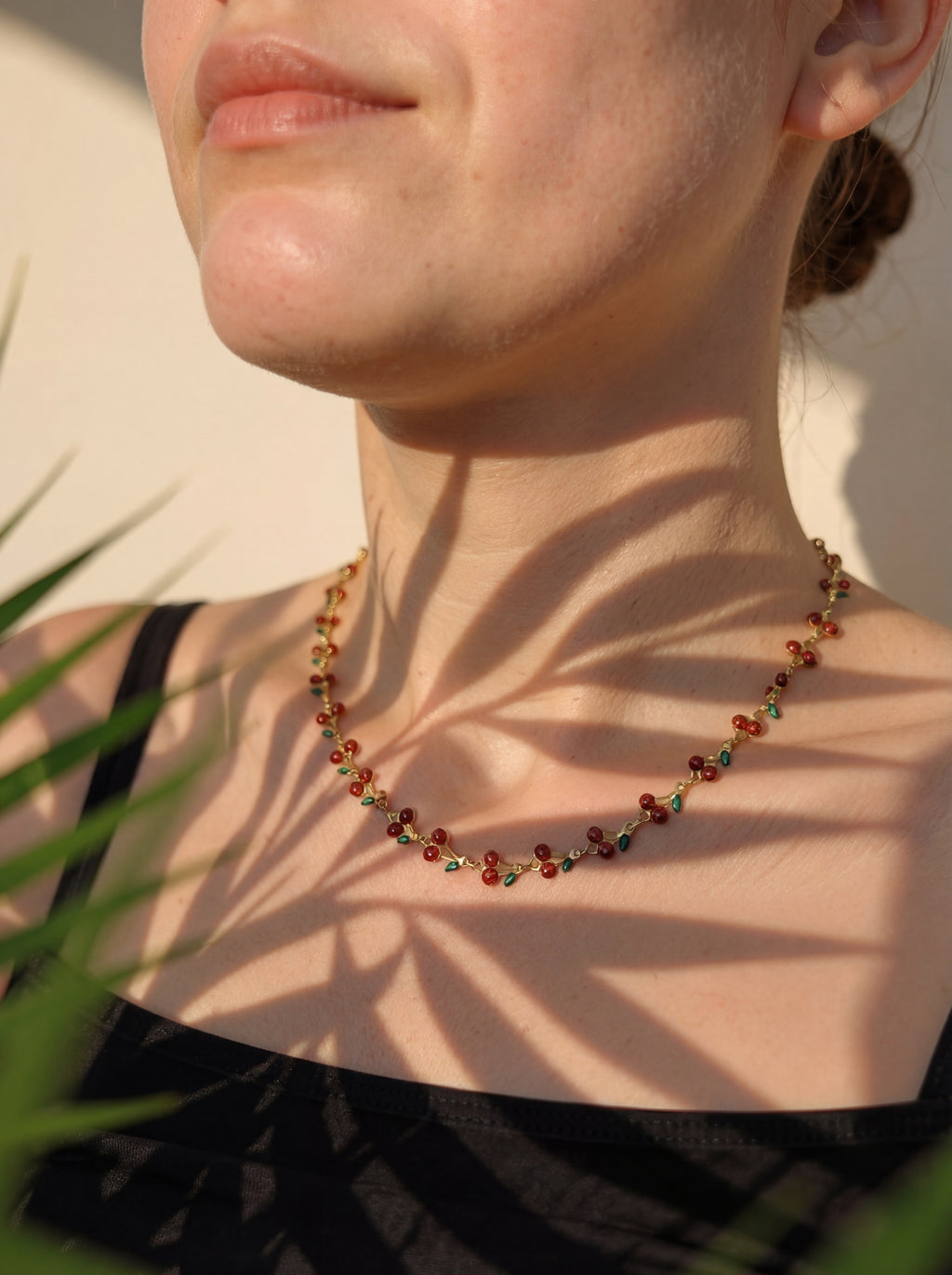 Close-up of a person wearing a beaded necklace with a blurred background