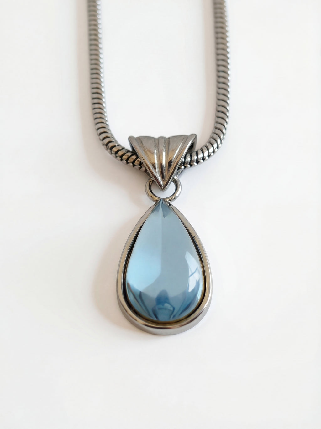 Necklace with a teardrop-shaped blue pendant on a white background