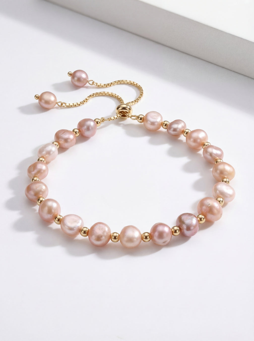 Pearl bracelet with gold accents on a white surface