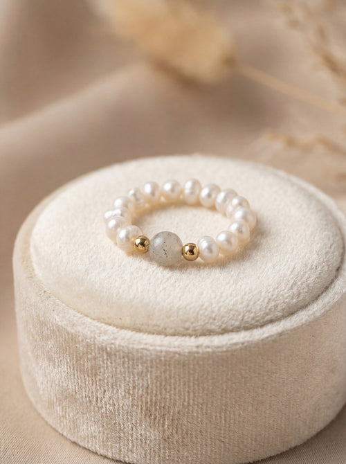 Pearl bracelet with gold accents on a beige jewelry box