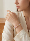 Woman wearing a pearl bracelet on a neutral background