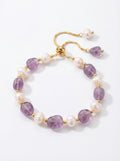 Bracelet with purple beads and pearls on a white background