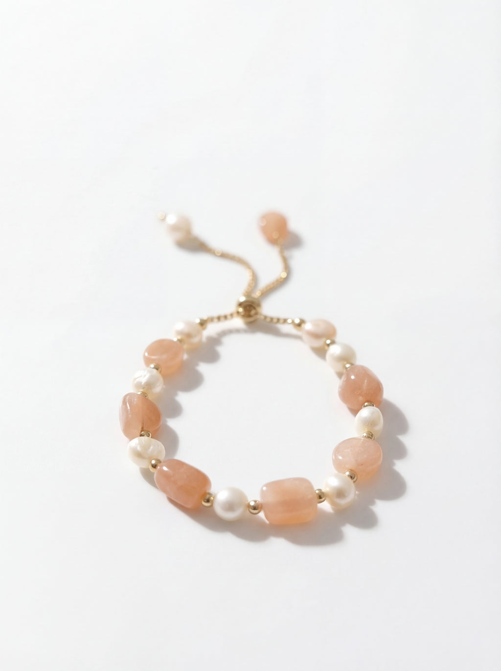 Bracelet with pink and white beads on a light background