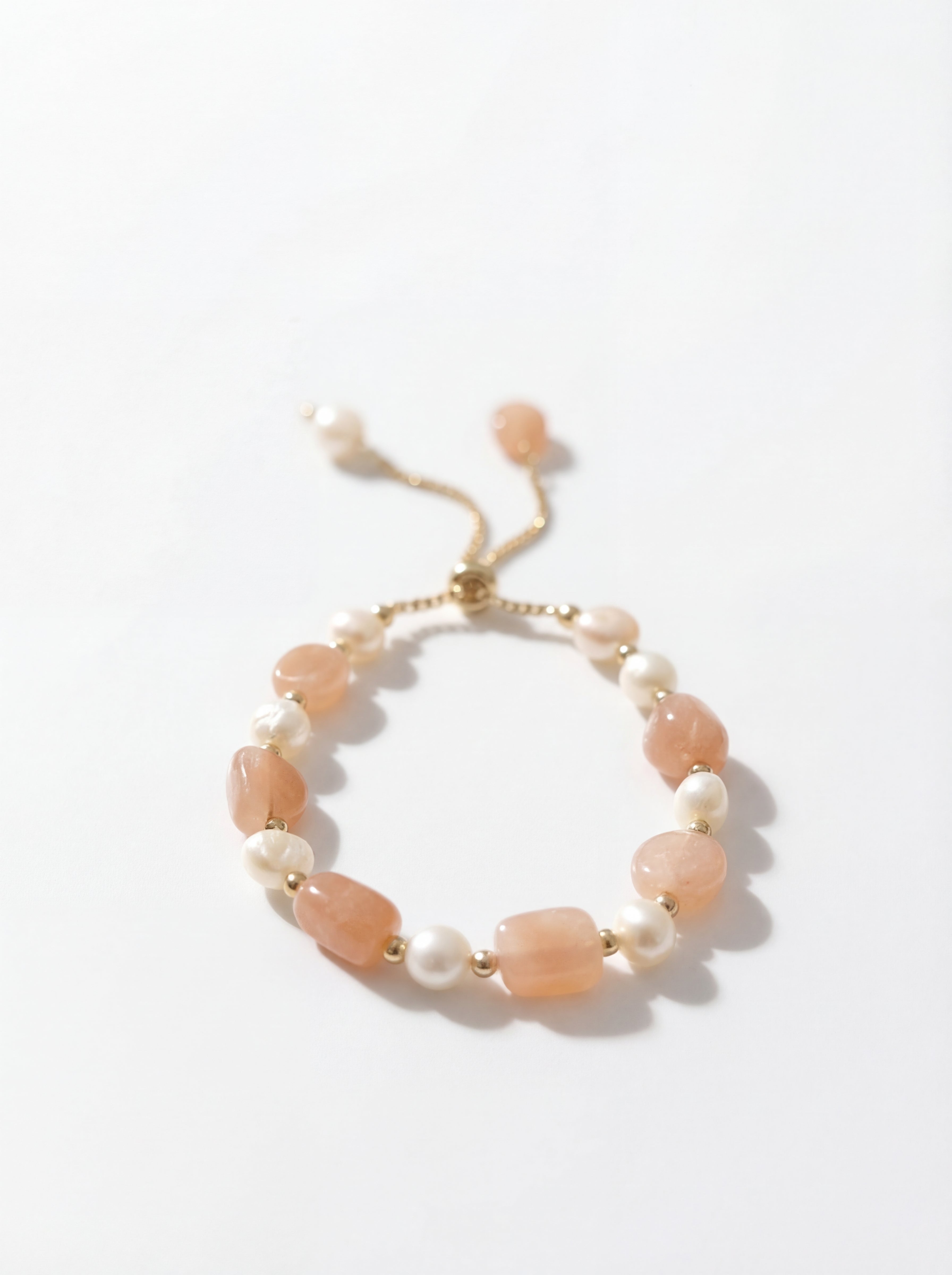 Bracelet with pink and white beads on a light background