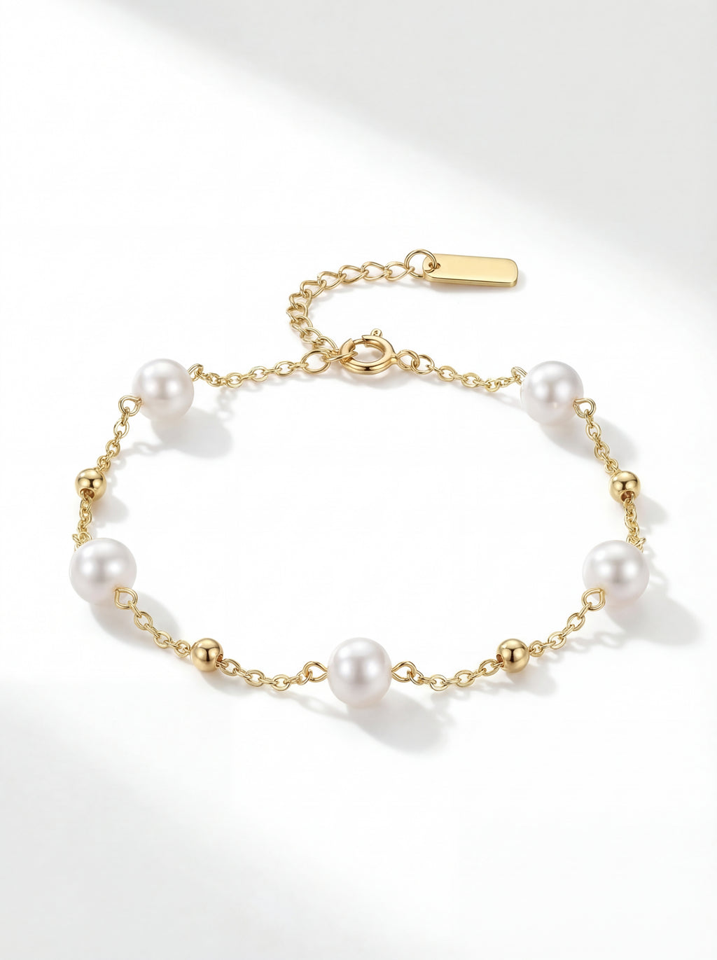 Pearl bracelet with gold chain on a white background