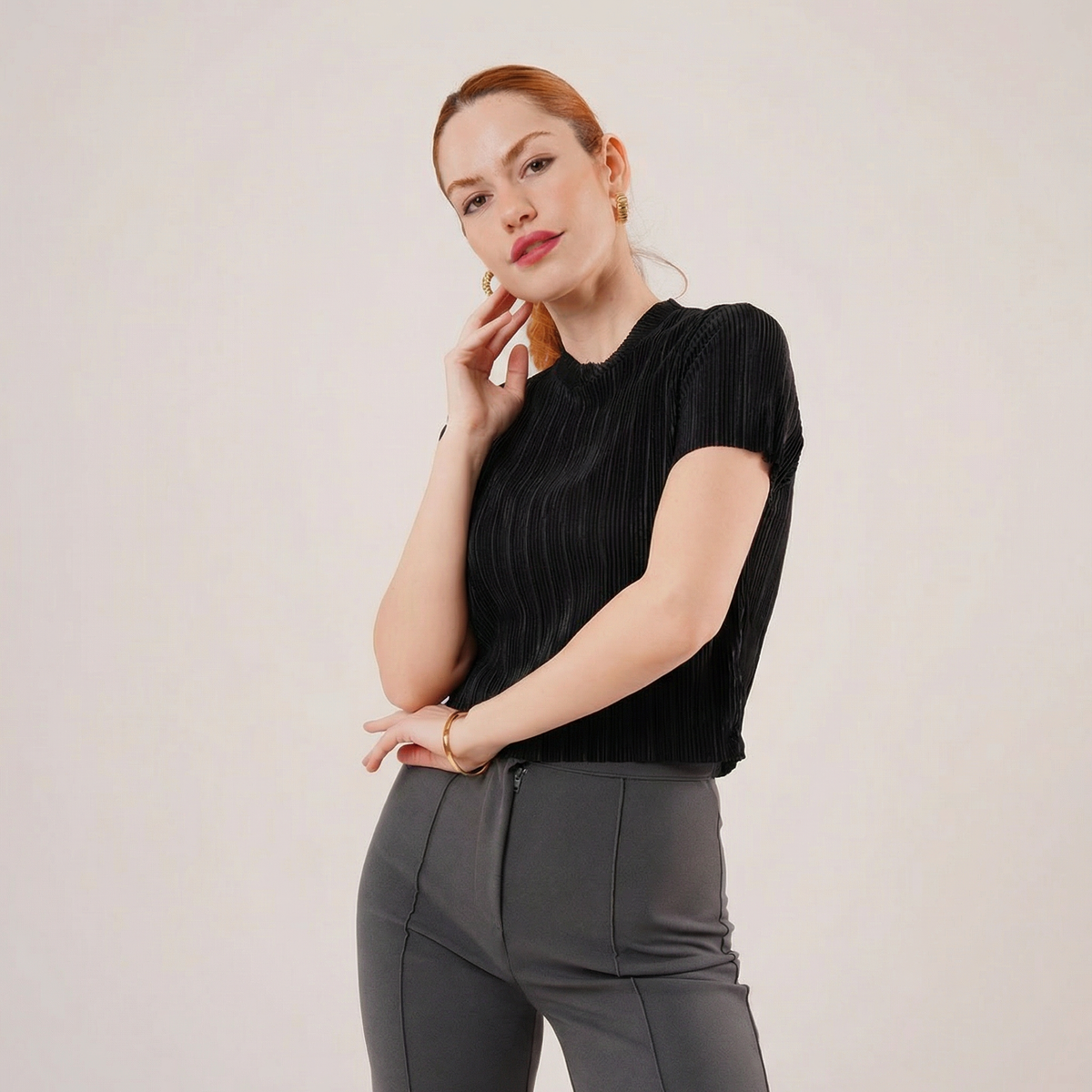 Schwarze Bluse mit mikrofeinen Falten, kurzen Ärmeln und dezentem Schimmer