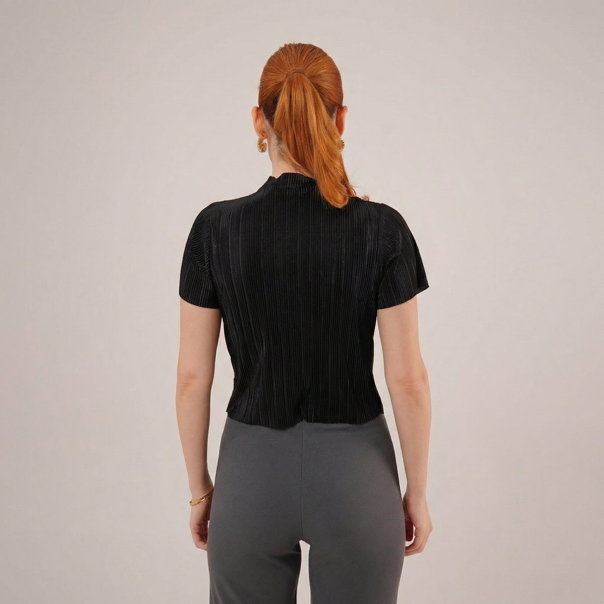 Schwarze Bluse mit mikrofeinen Falten, kurzen Ärmeln und dezentem Schimmer
