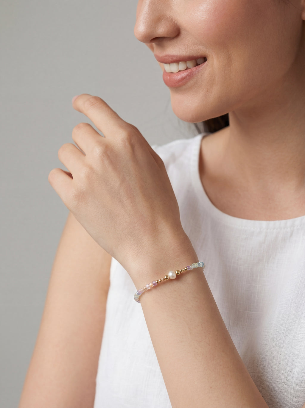 Woman wearing a bracelet on a plain background