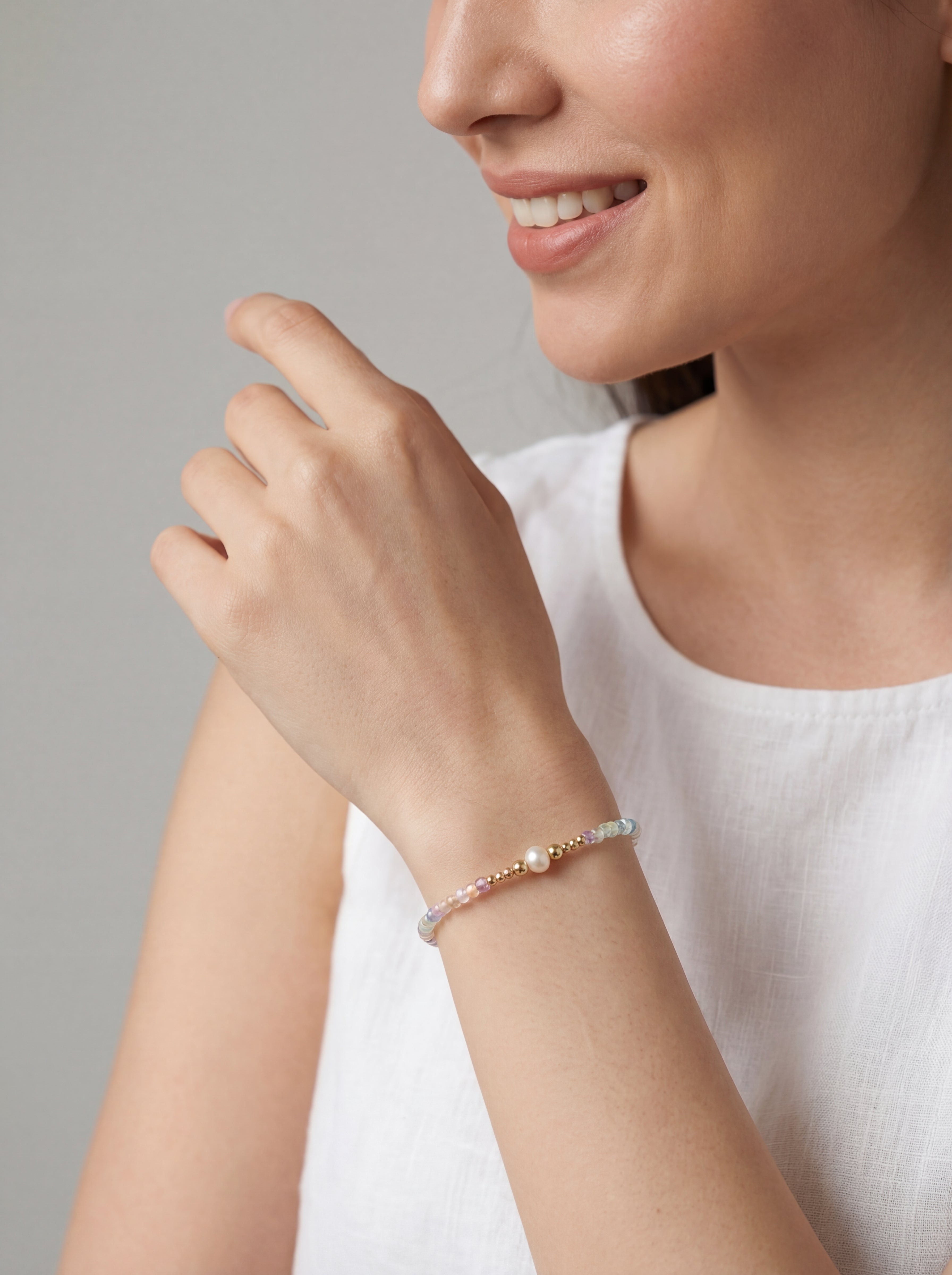 Woman wearing a bracelet on a plain background