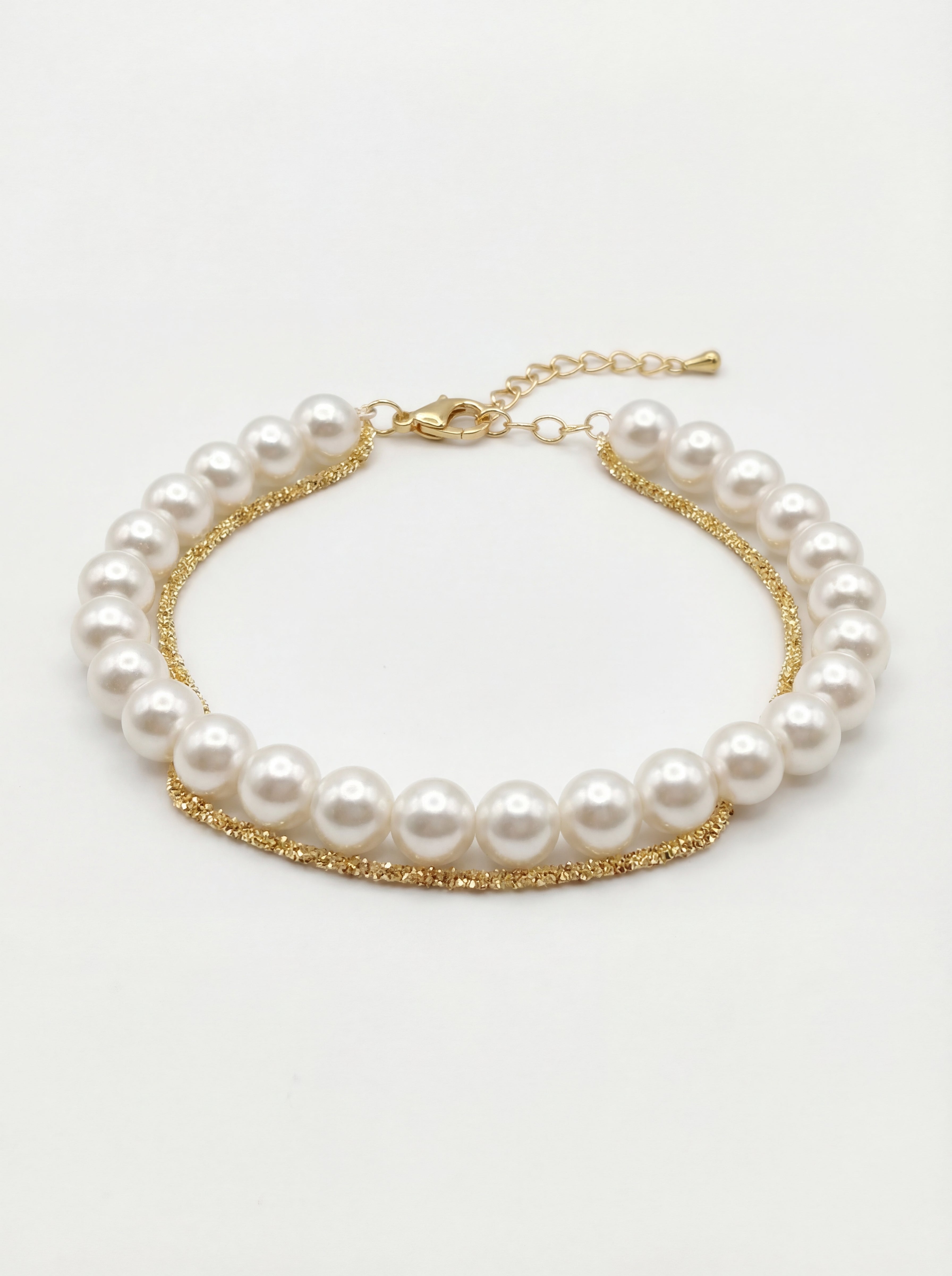 Pearl bracelet with gold chain on a white background